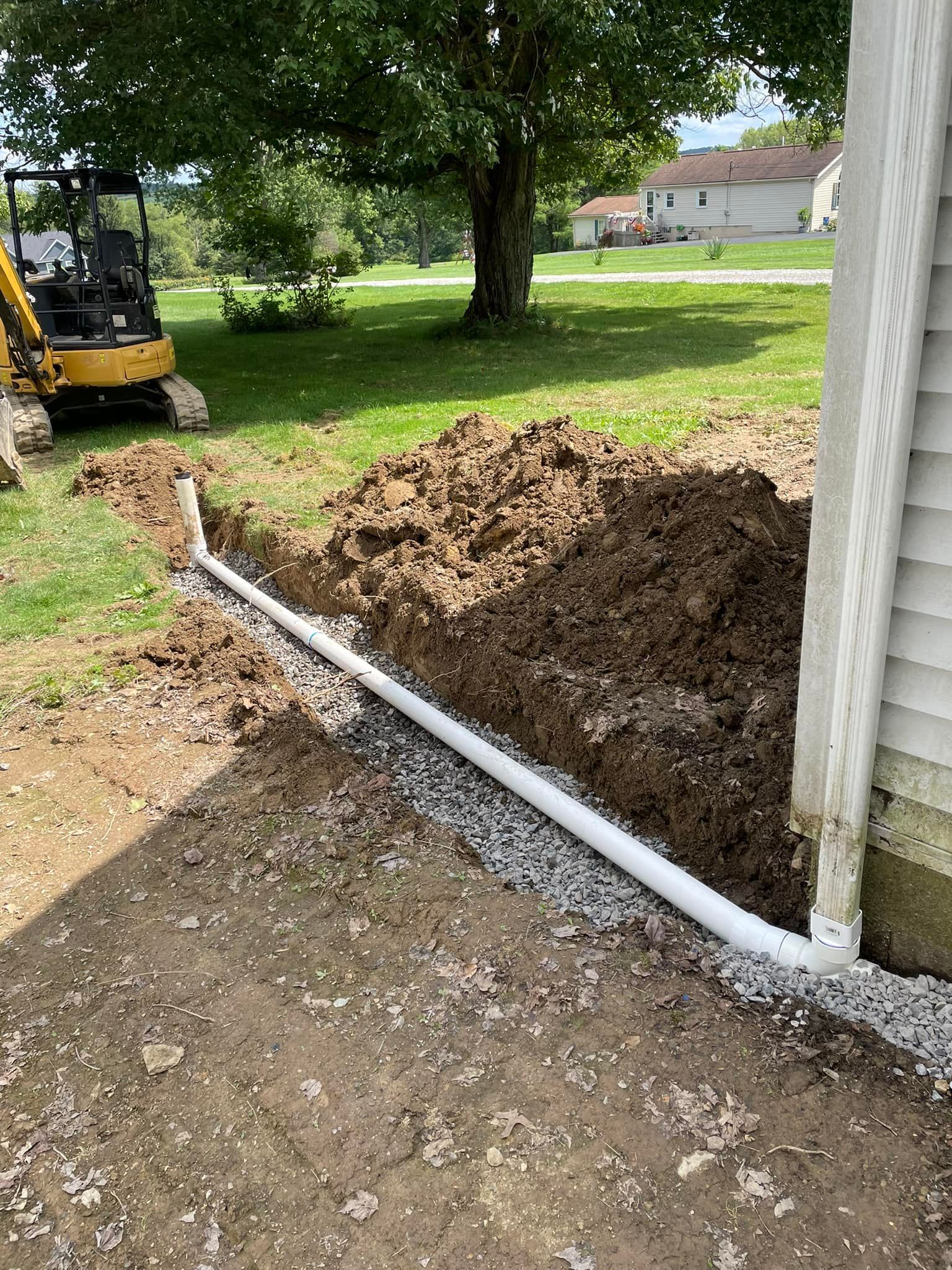 A drain pipe is being installed on the side of a house.