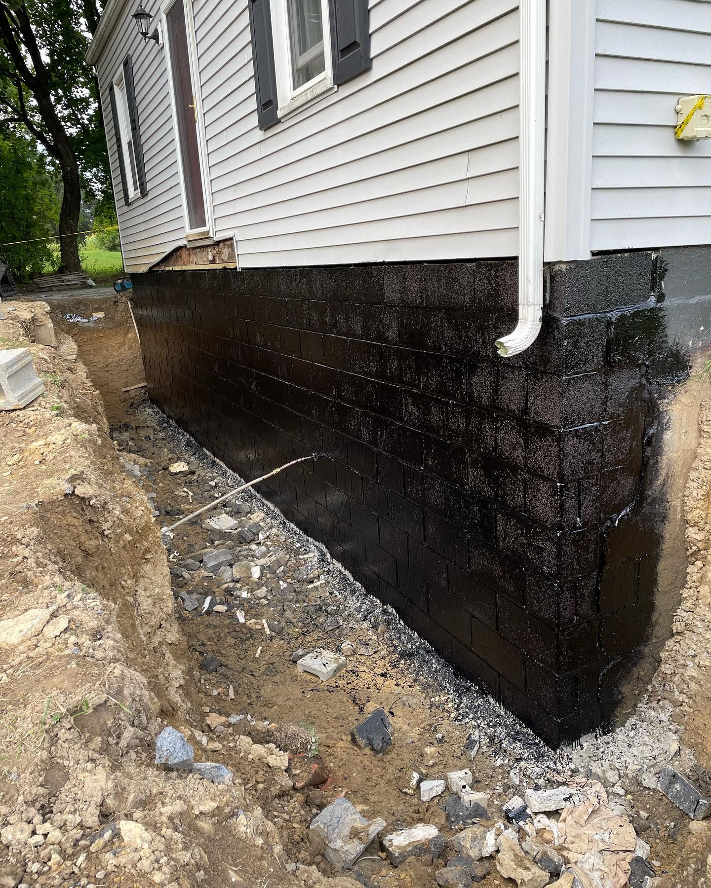 A white house with a black foundation is being built.