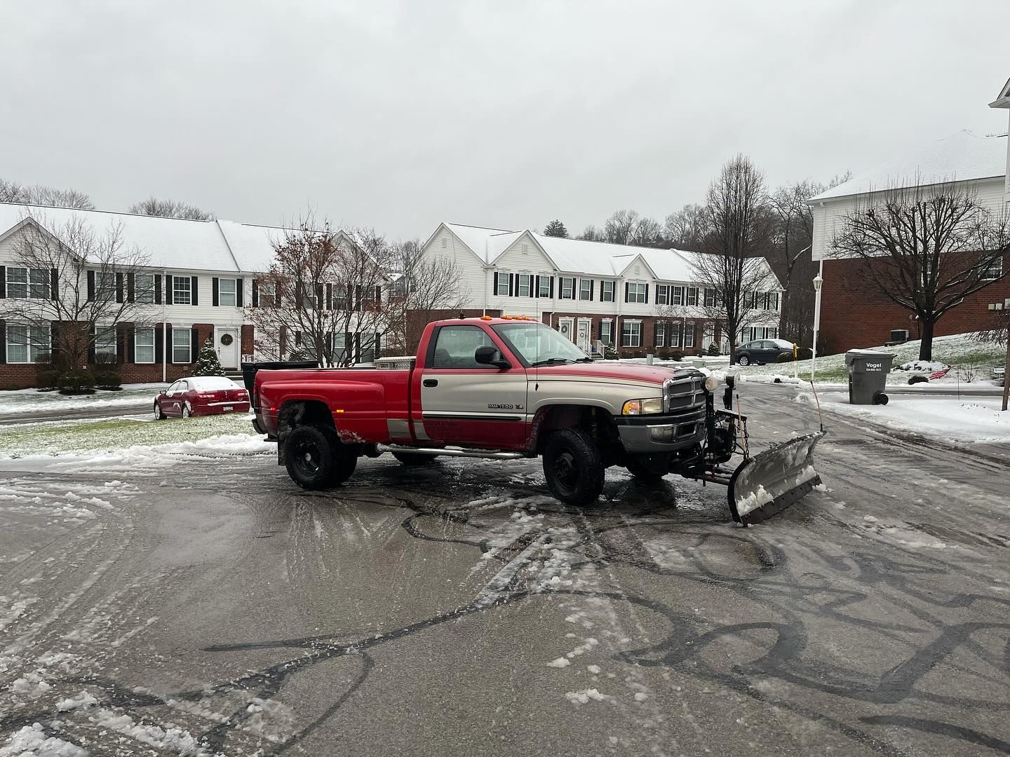 A red truck with a snow plow attached to it