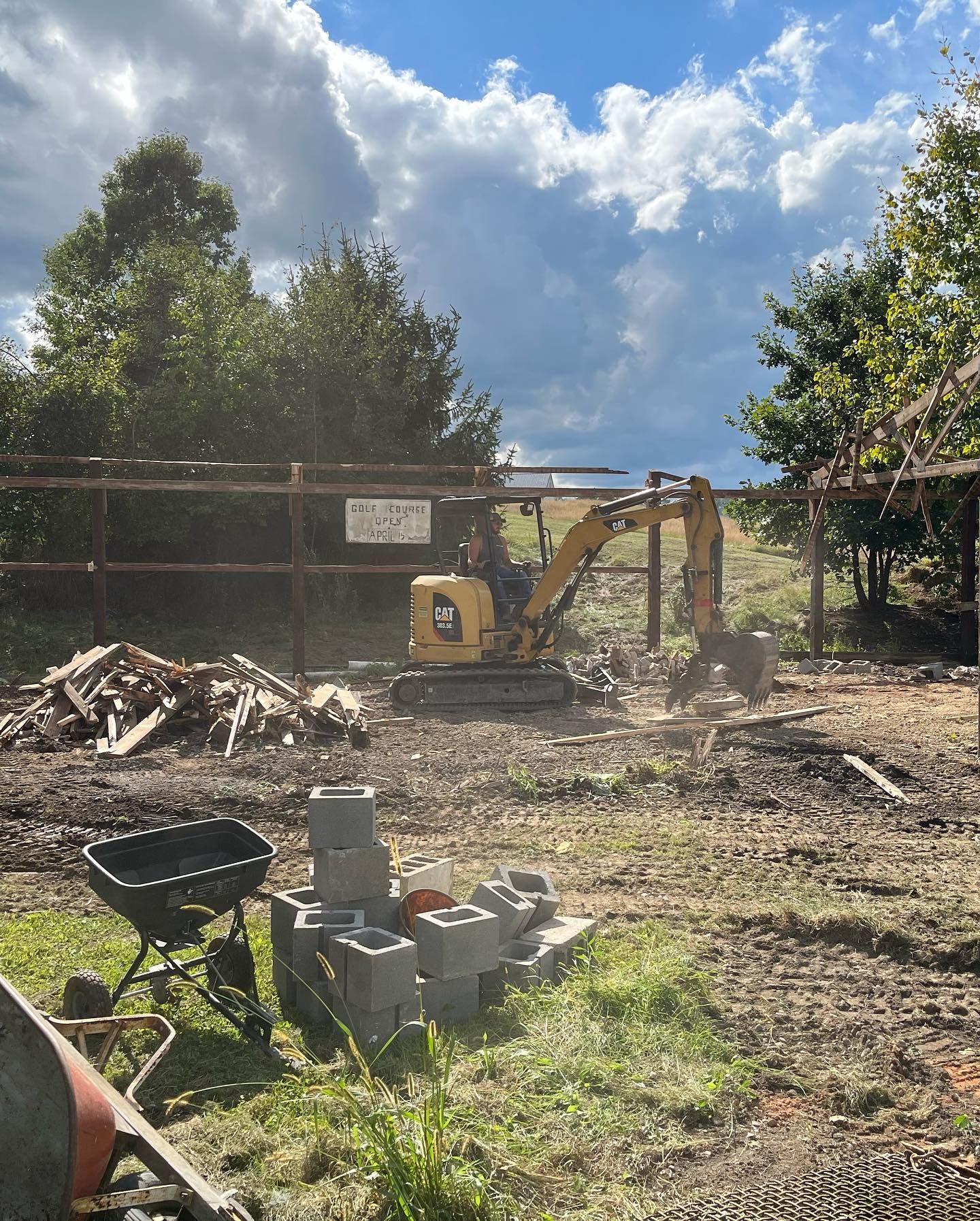 A construction site with a bulldozer and a wheelbarrow in the foreground.