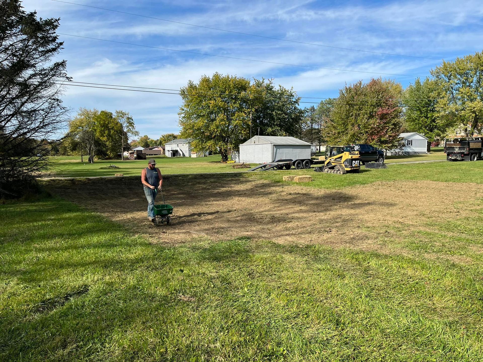 A man is standing in the middle of a grassy field.