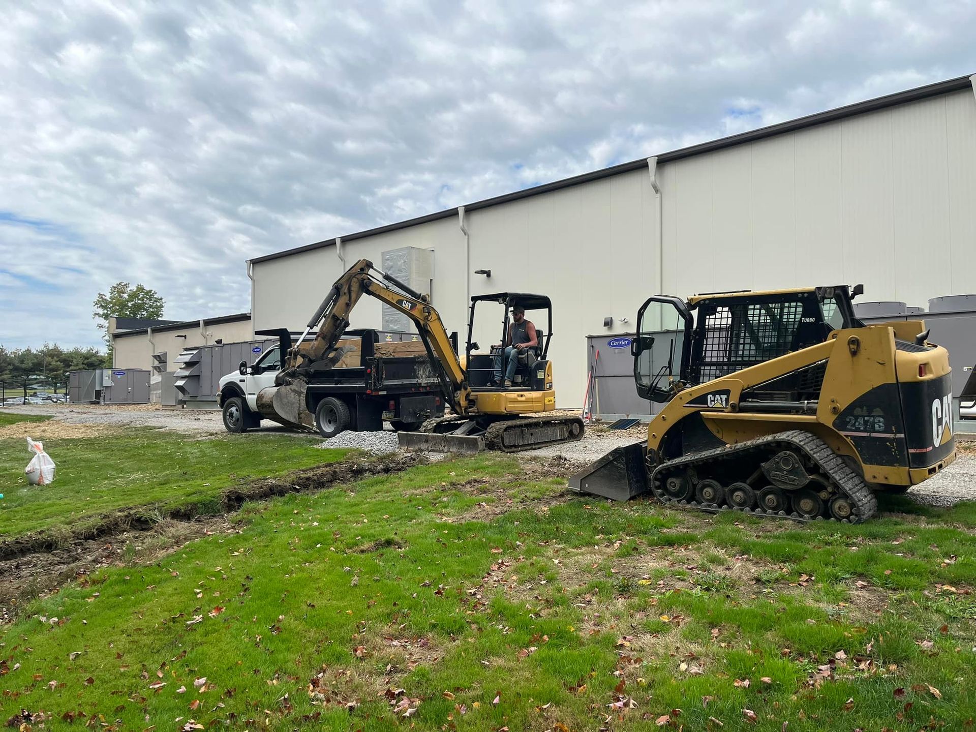 Two construction vehicles are parked in front of a building.