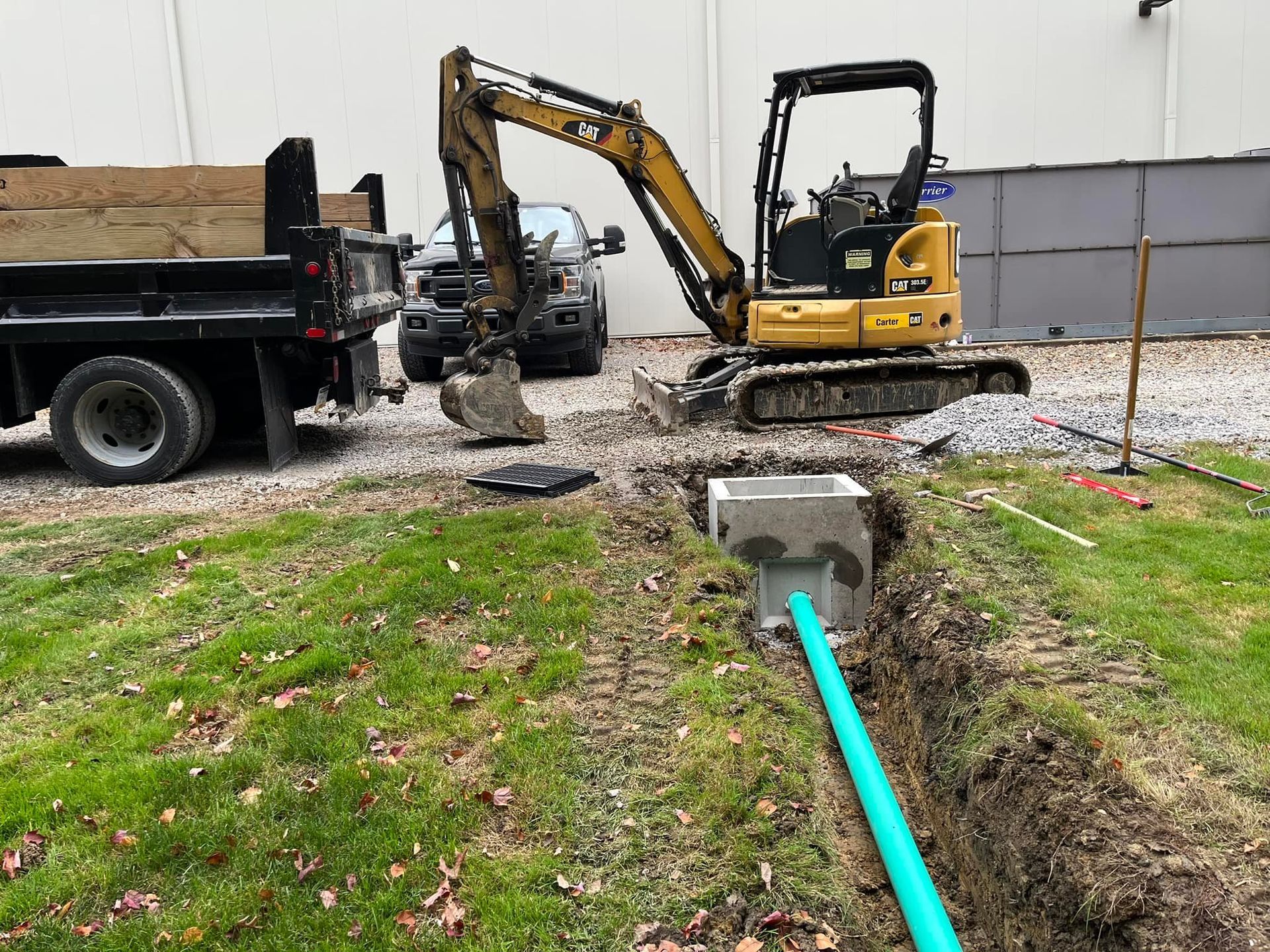 A yellow excavator is digging a hole in the ground next to a dump truck.