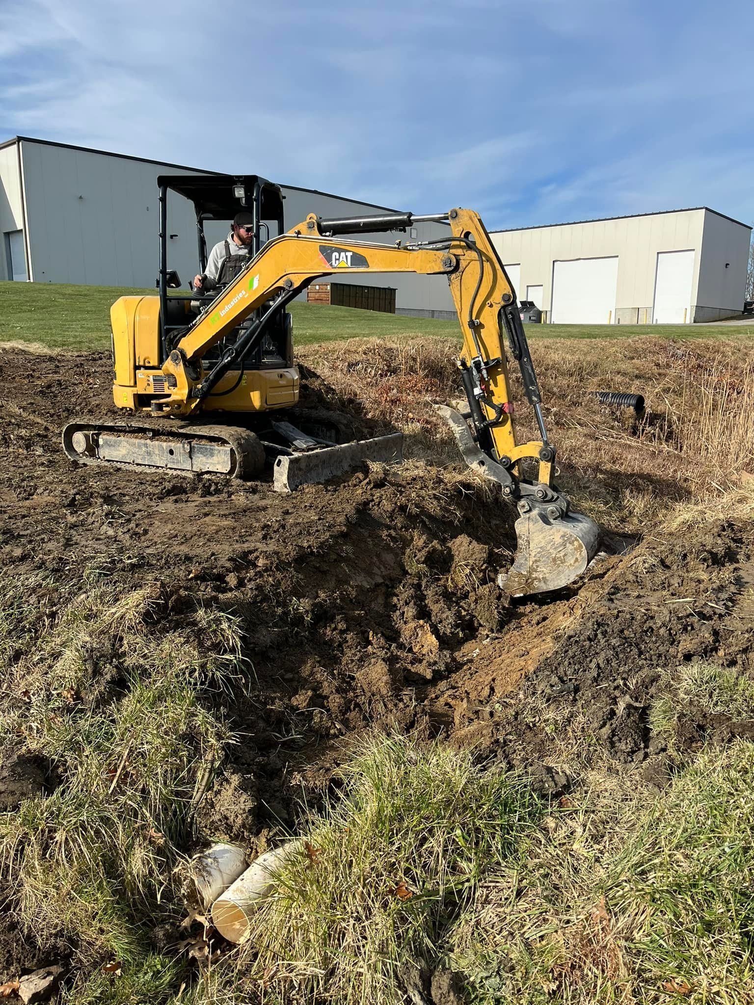 A yellow excavator is digging a hole in the dirt.