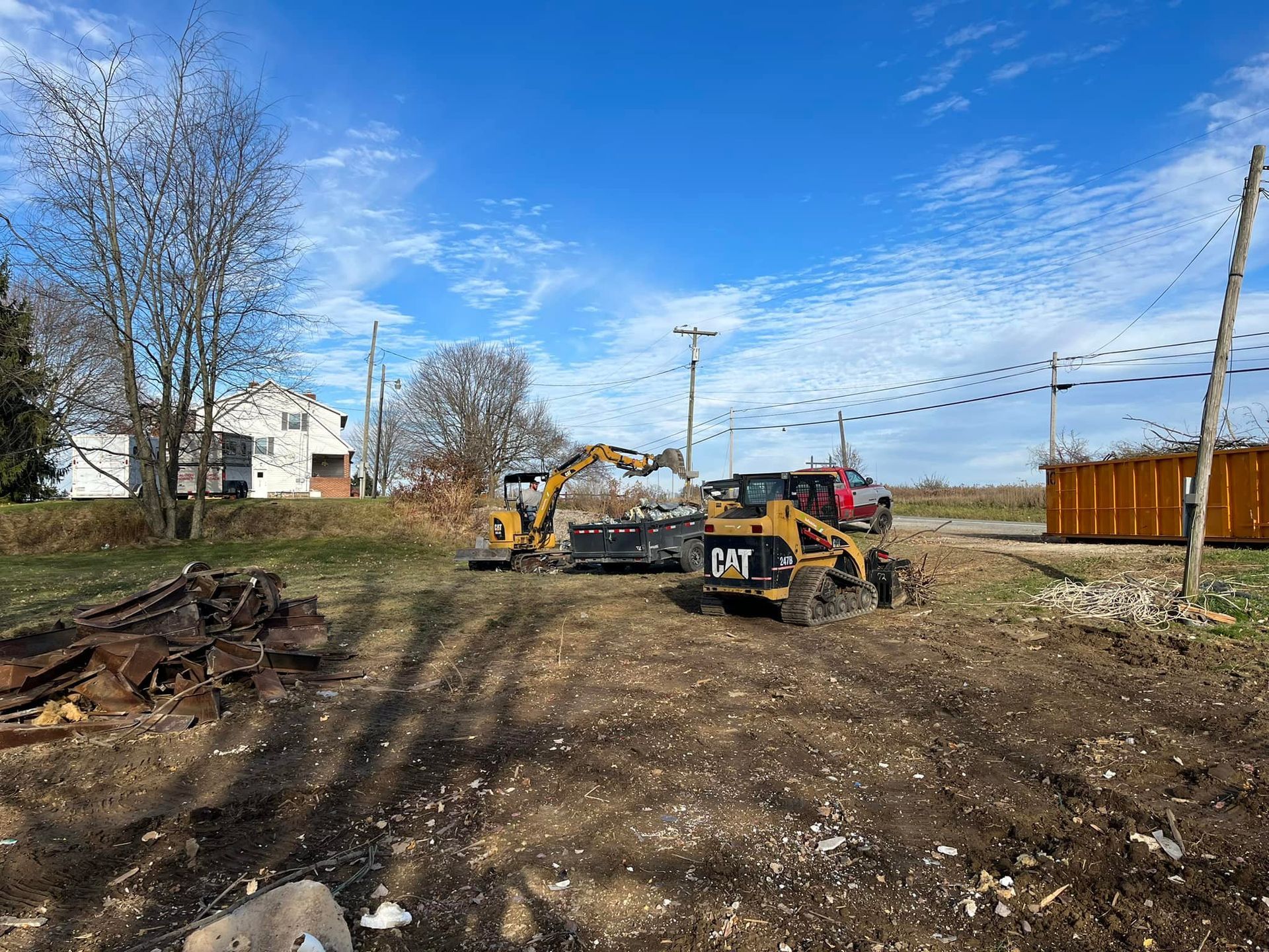 A couple of tractors are sitting on top of a dirt field.