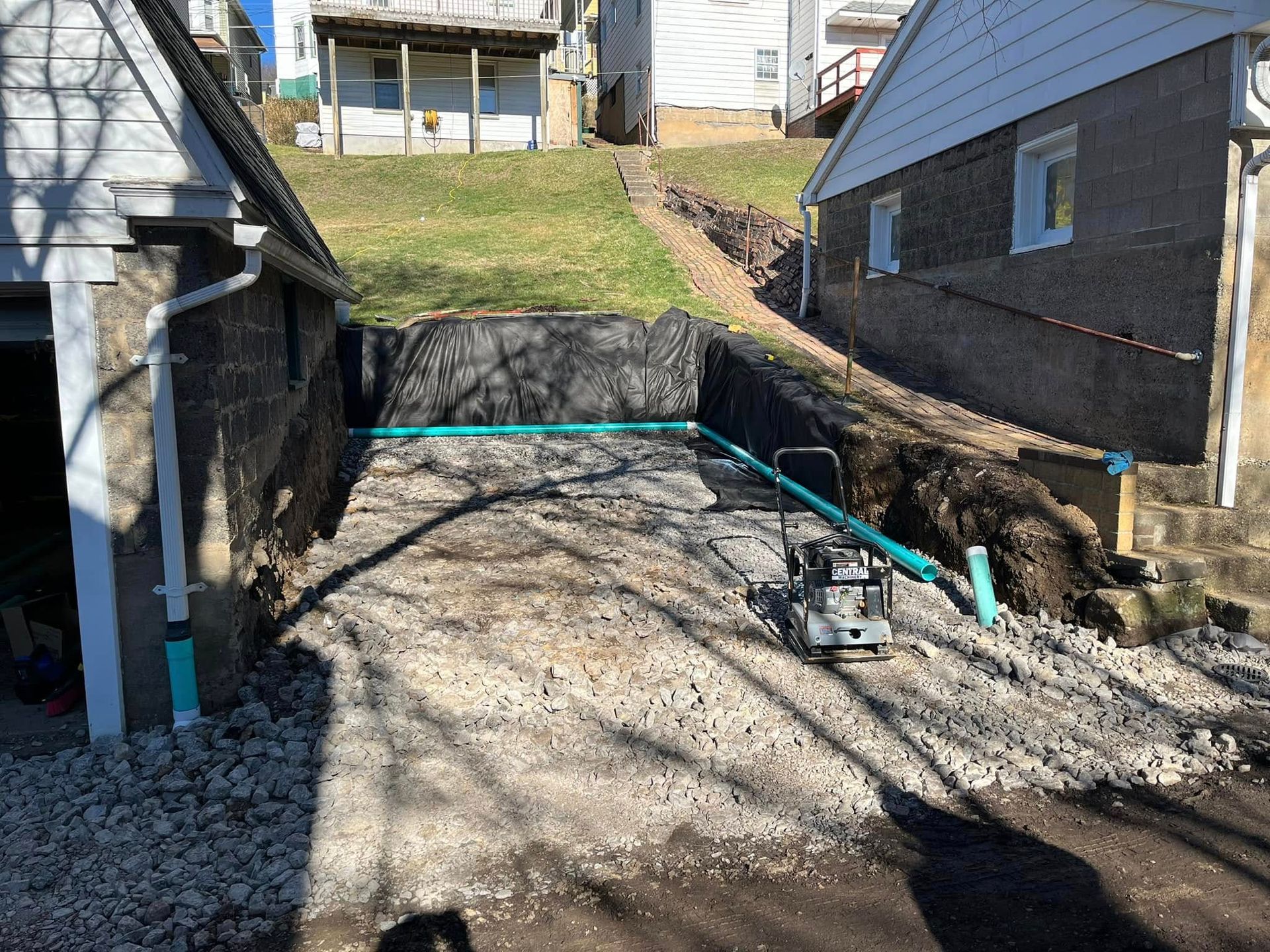 A drainage system is being installed in the backyard of a house.