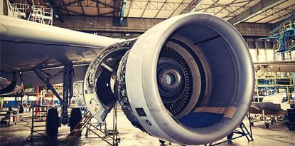 Airplane engine being worked on in a maintenance hangar.