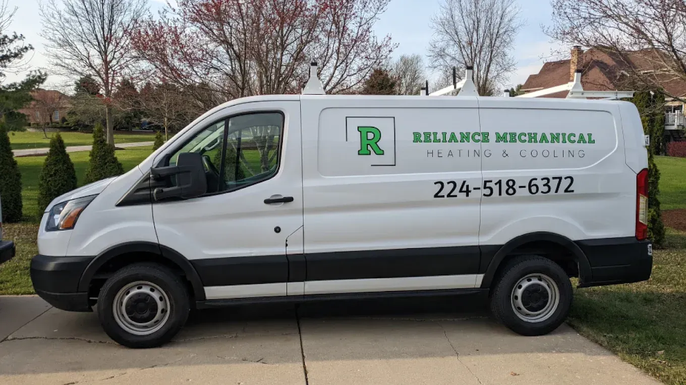 White Reliance Mechanical van parked on a driveway, phone number displayed: 224-518-6372.