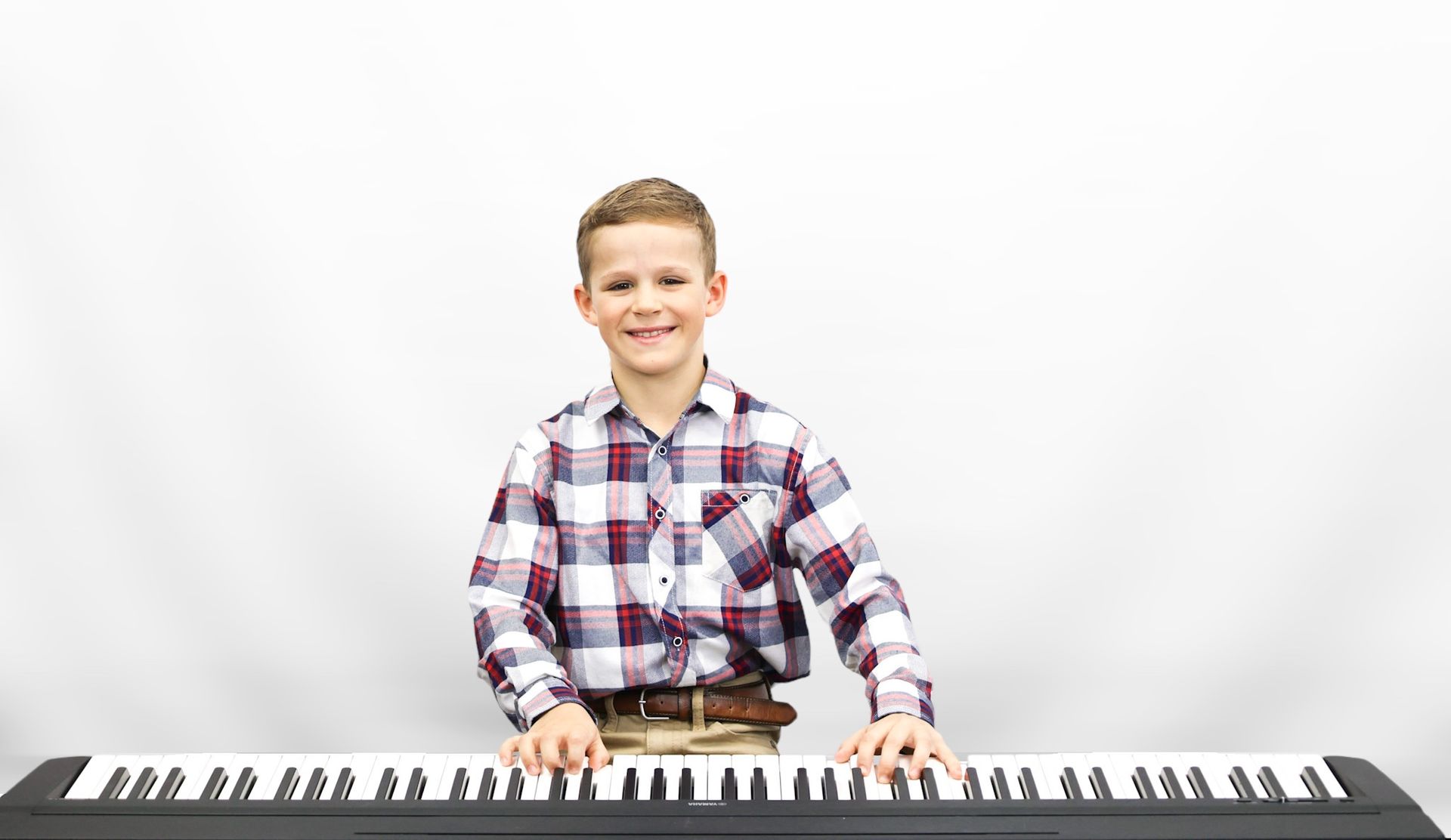 A person is playing a piano with their hands on the keys.