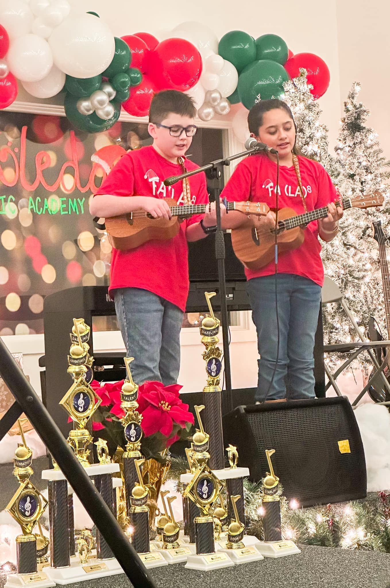 A young boy is playing drums in a dark room.