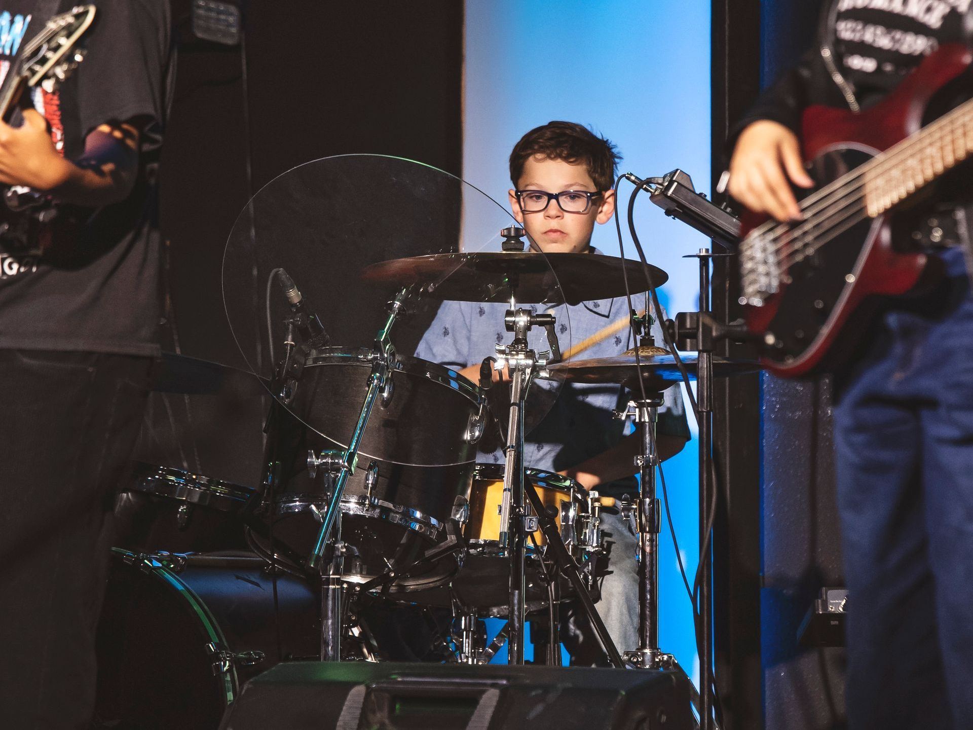 A man playing a guitar and a boy playing drums