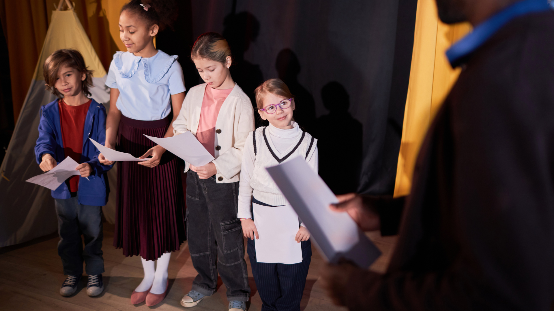 A woman is singing into a microphone in front of a group of people.