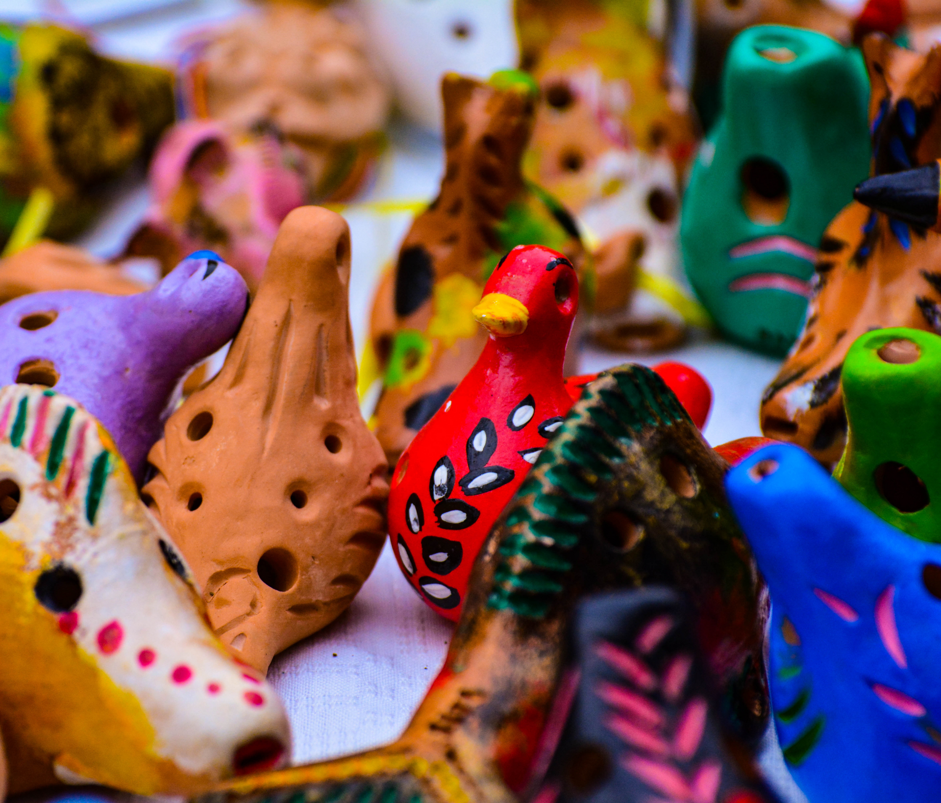 A bunch of colorful clay birds are sitting on a table