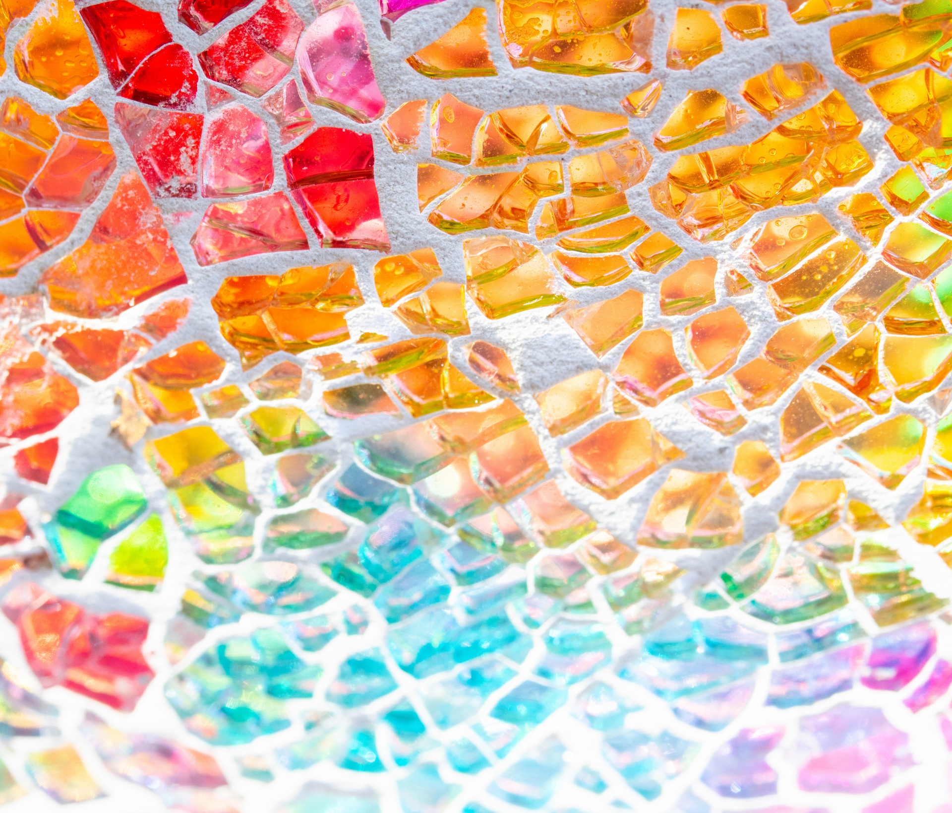 A close up of a rainbow colored mosaic on a white surface.