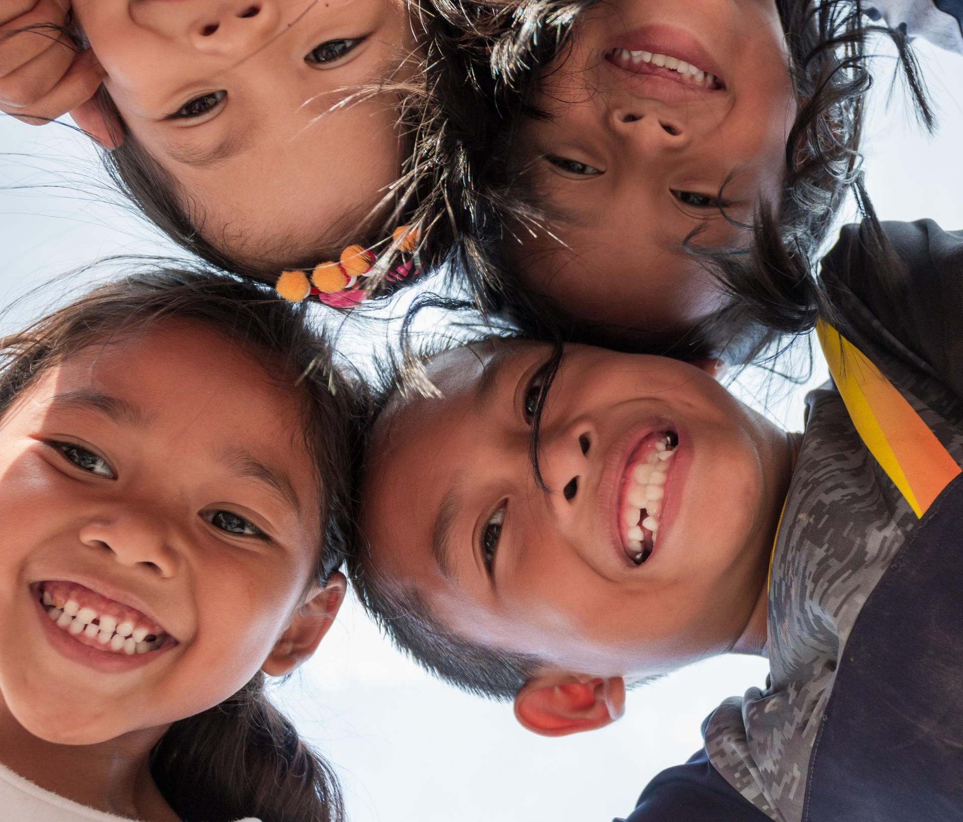 A group of children are looking down at the camera and smiling