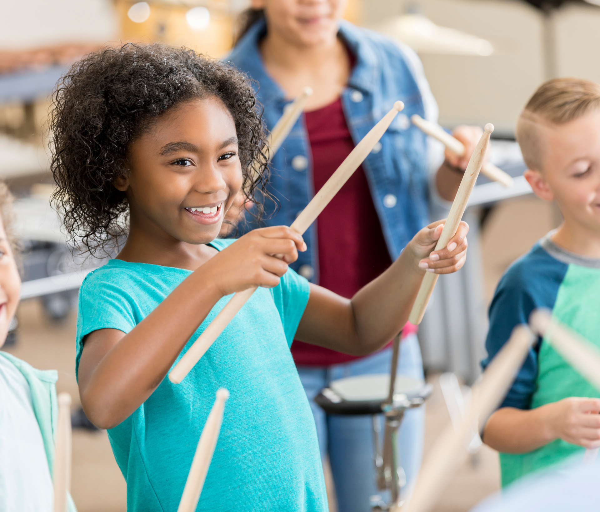 A group of children are playing drums in a classroom.