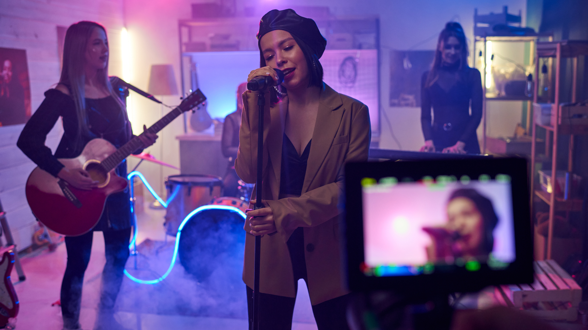 A woman is singing into a microphone in front of a group of people.