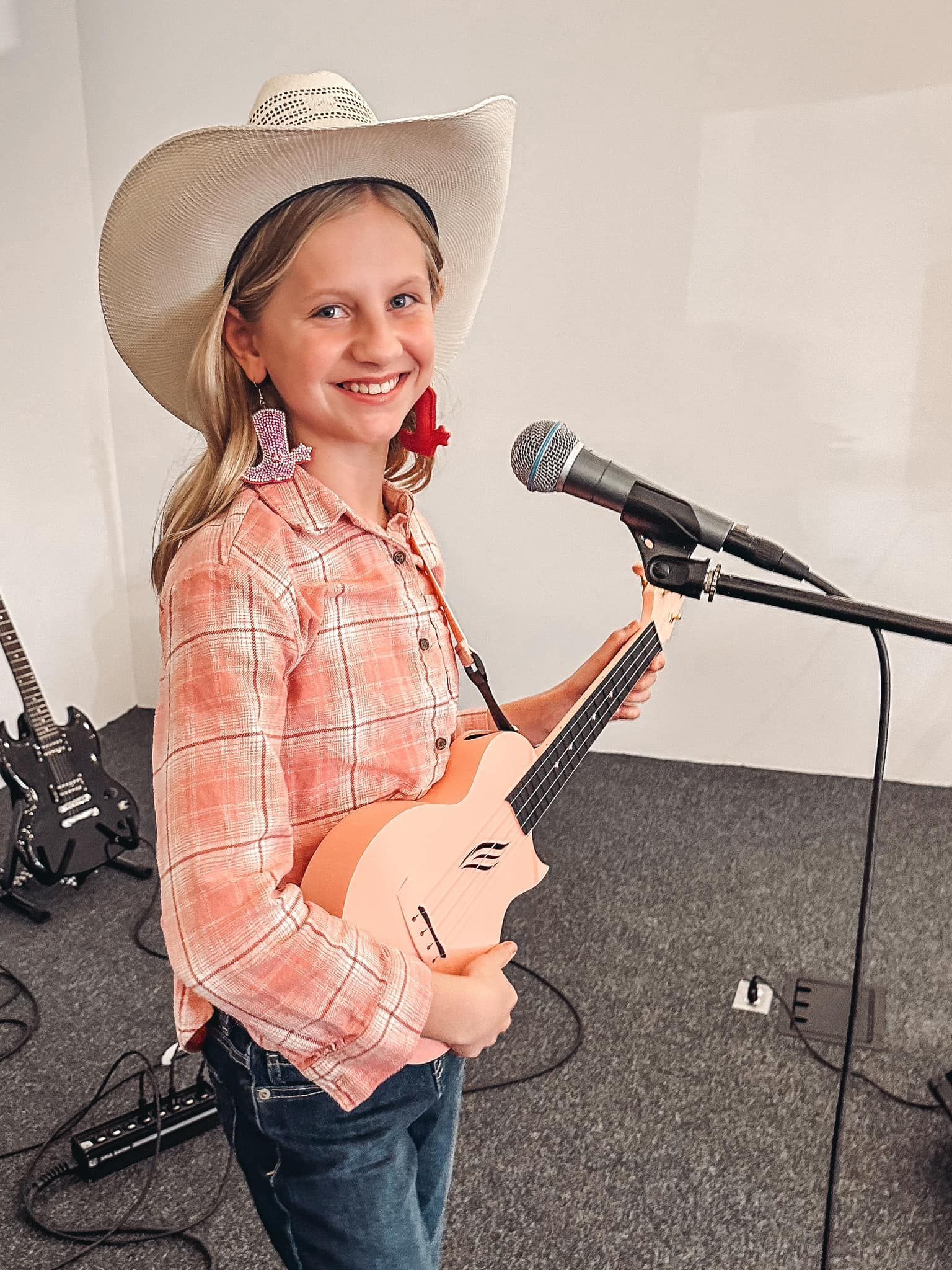 A young girl is playing a piano in a room.