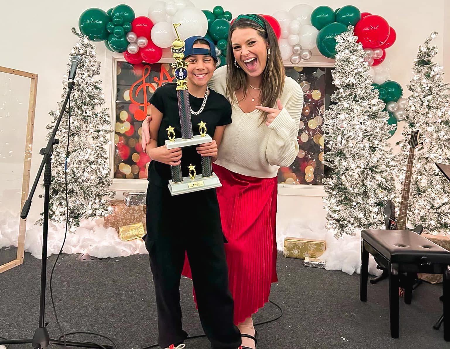 Two women are standing next to each other holding a trophy.