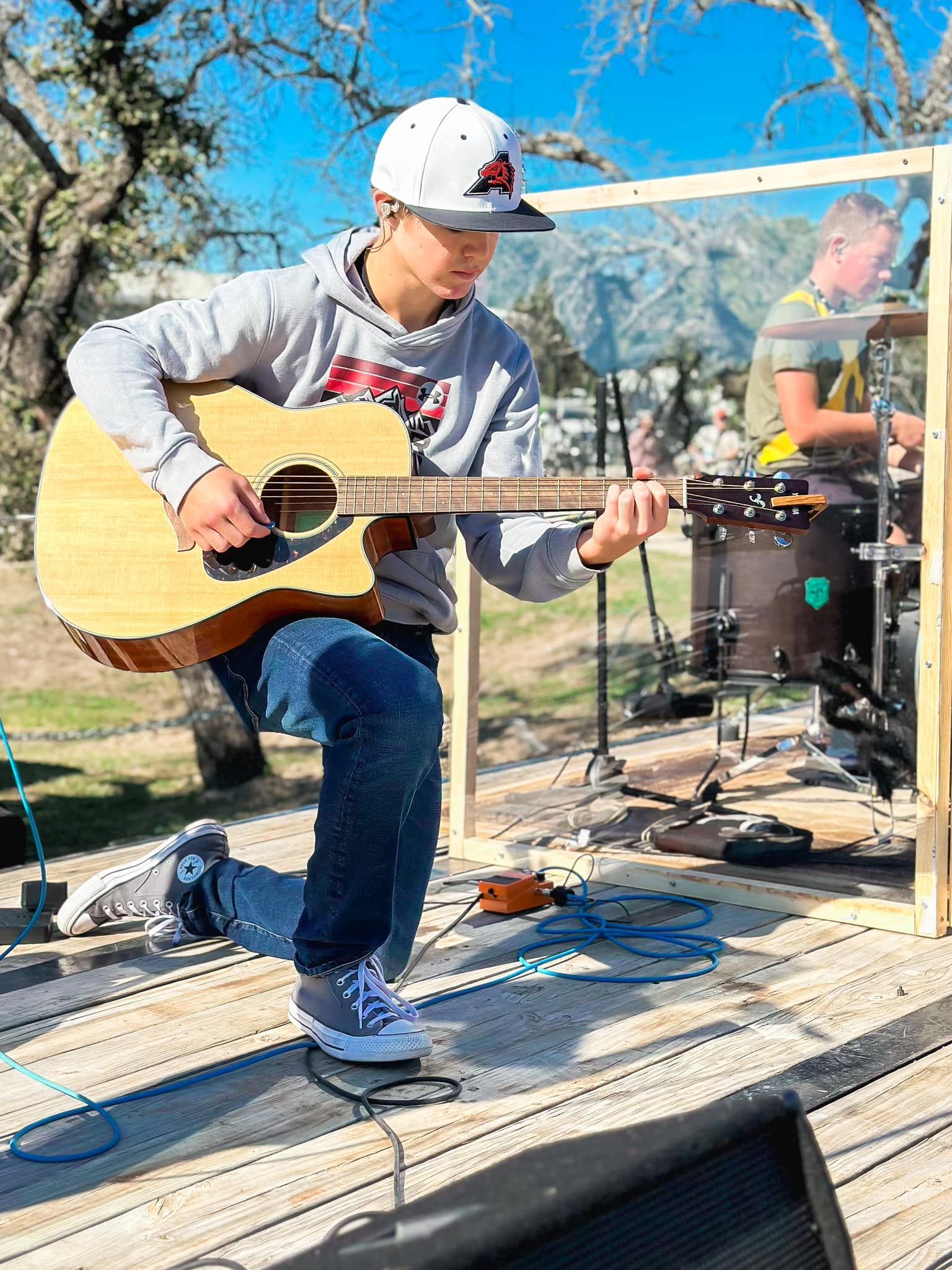 A young girl is making a rock and roll sign in front of a microphone.