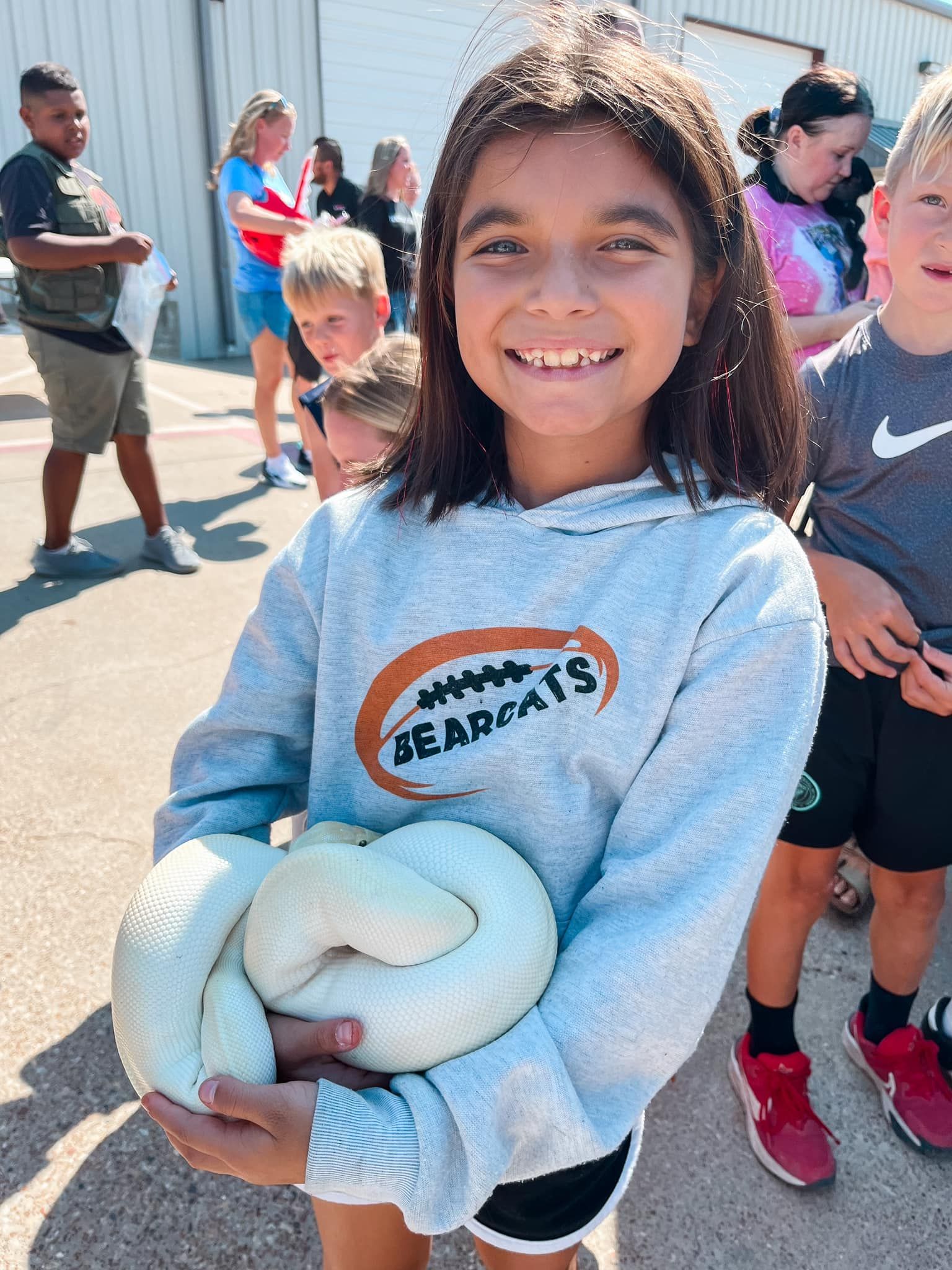 A young girl is playing a keyboard and smiling.