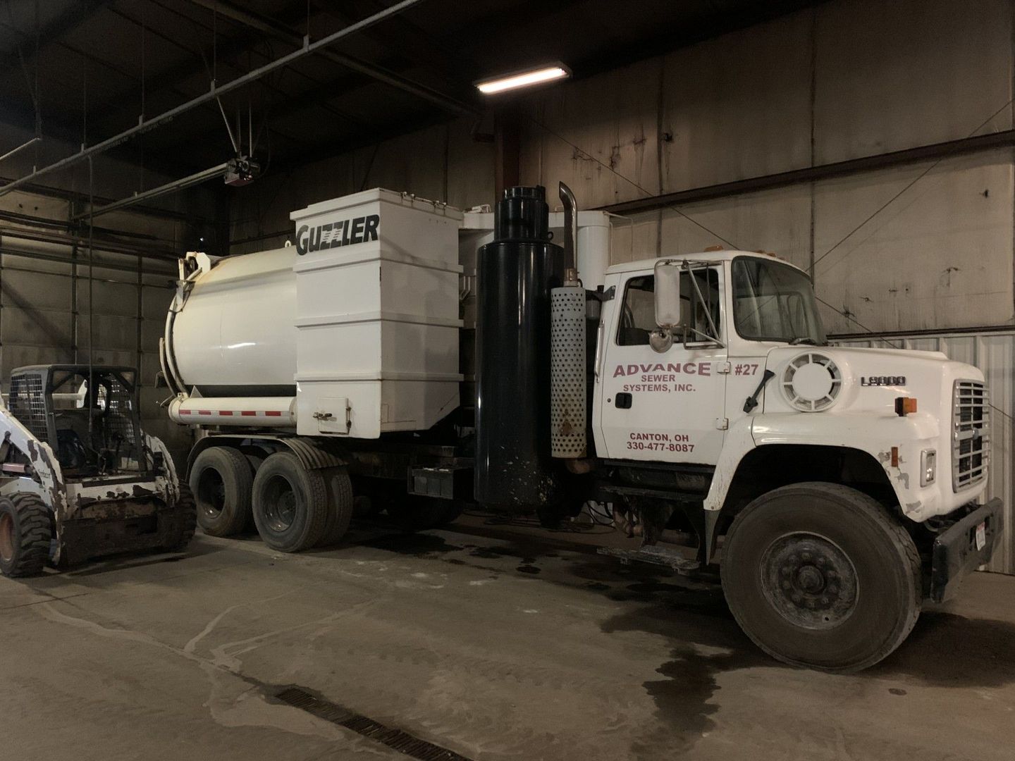 White vacuum truck, labeled 