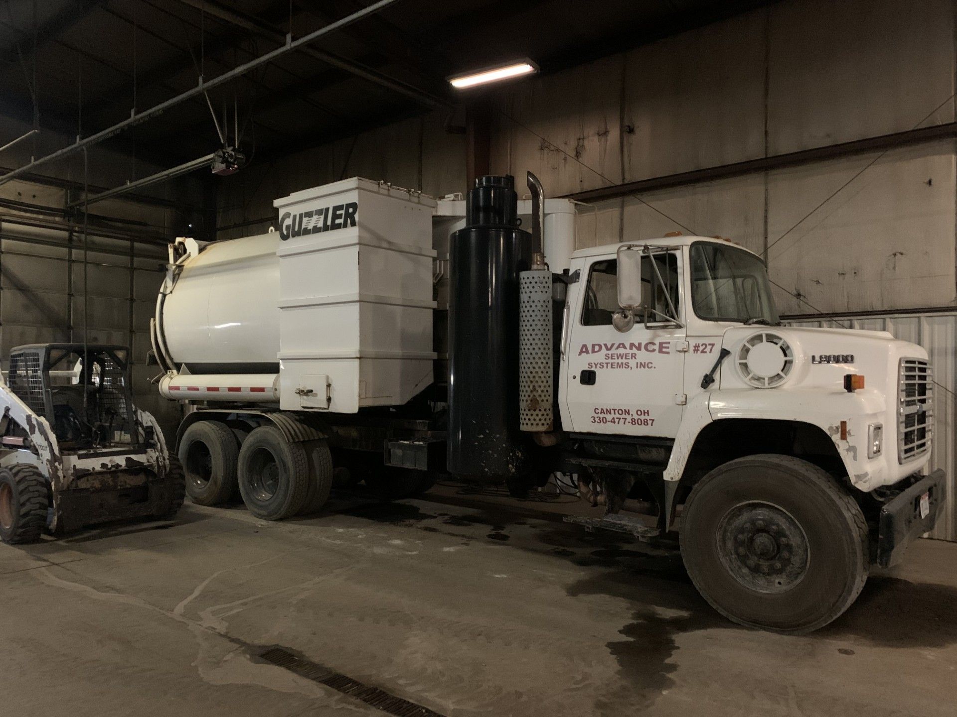 White vacuum truck, labeled 