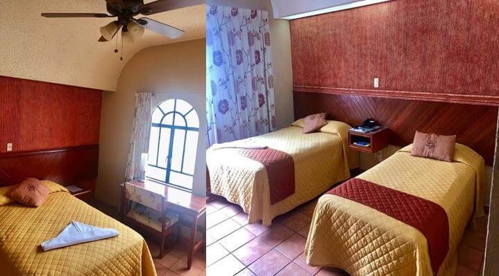 Una habitación de hotel con dos camas y un ventilador de techo.