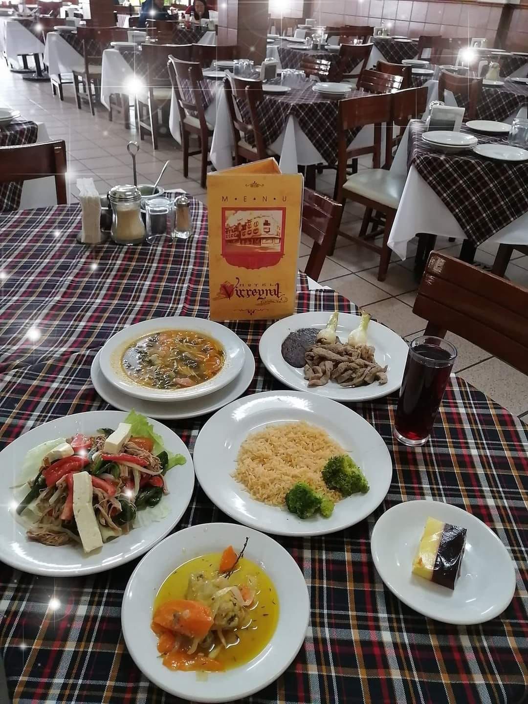 Una mesa con platos de comida y un menú sobre ella.