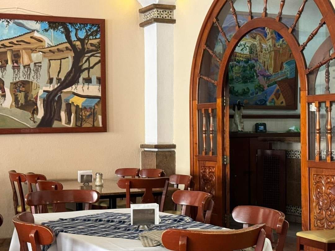 Un restaurante con mesas y sillas y un cuadro en la pared.