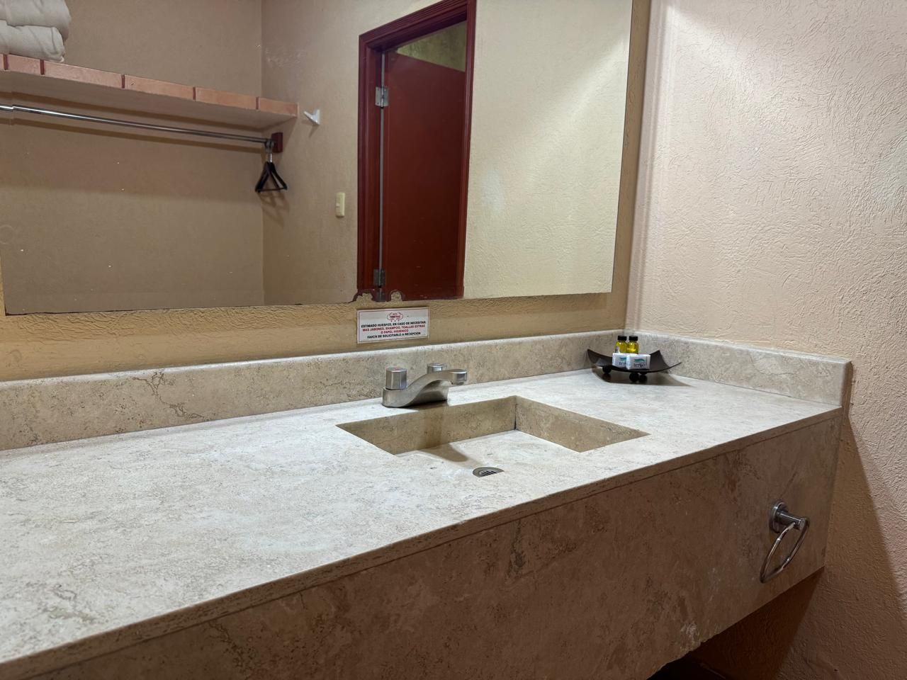 Un baño en una habitación de hotel con un lavabo y un espejo.
