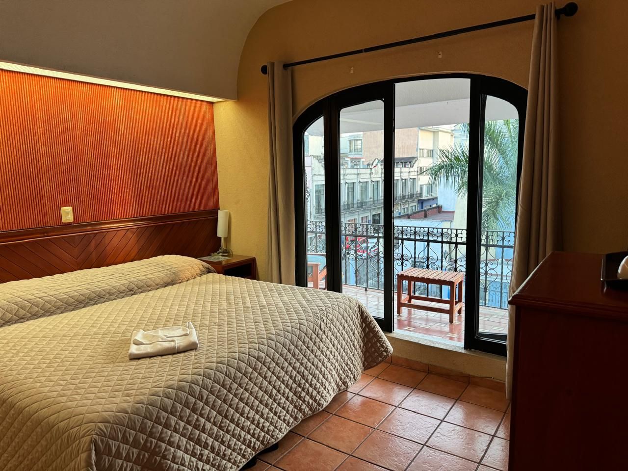 Una habitación de hotel con una cama y un balcón.