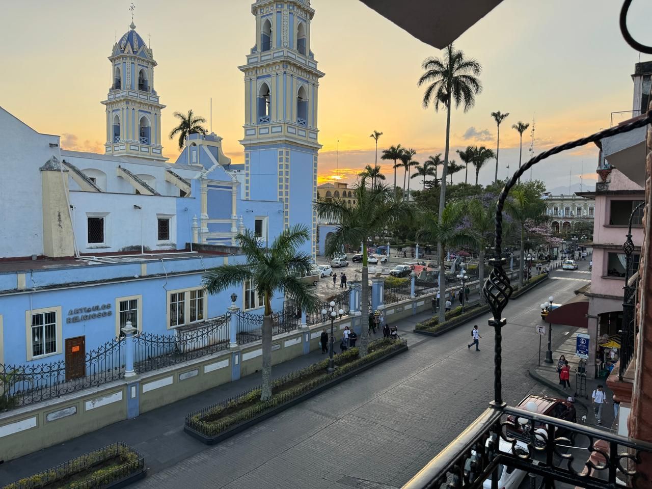Una vista de una calle de la ciudad con una iglesia al fondo.