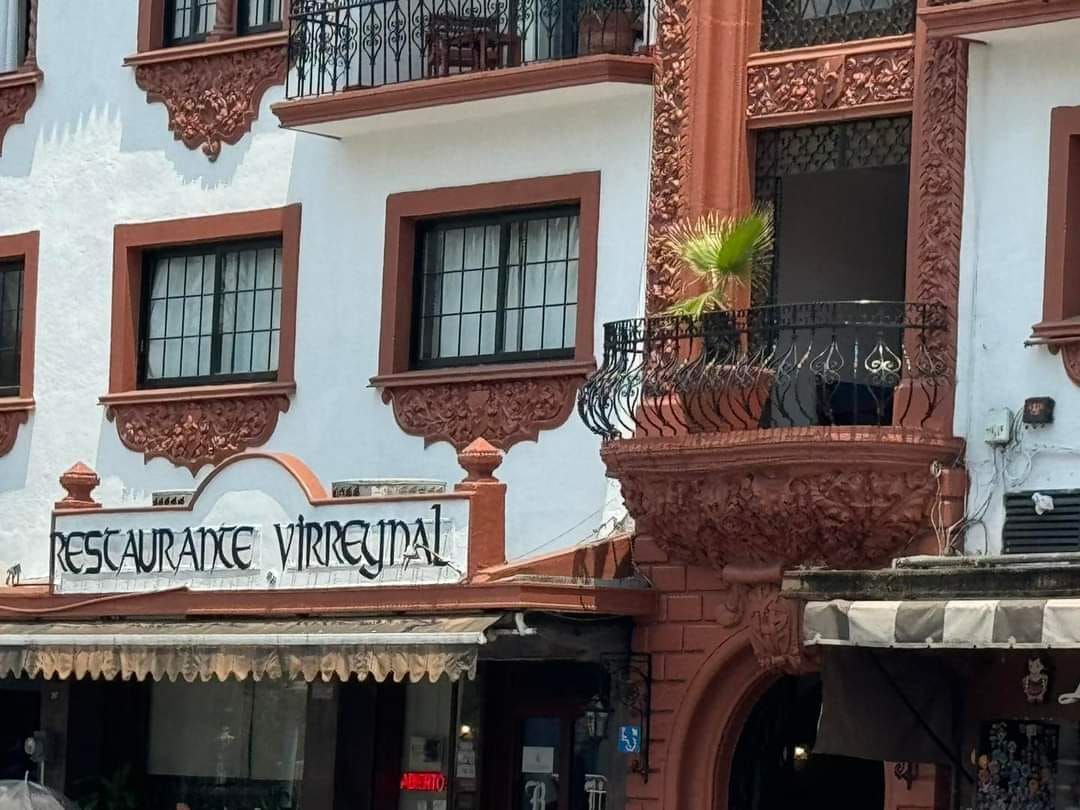 Un edificio blanco con un cartel que dice restaurante virquital