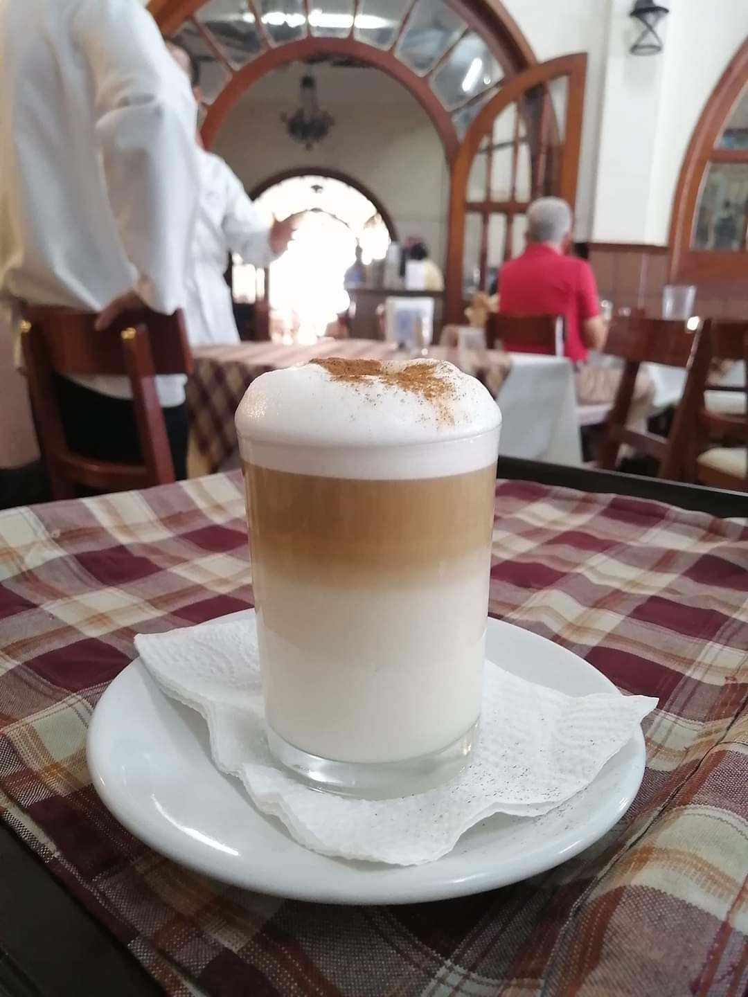 Una taza de capuchino en un platillo sobre una mesa.