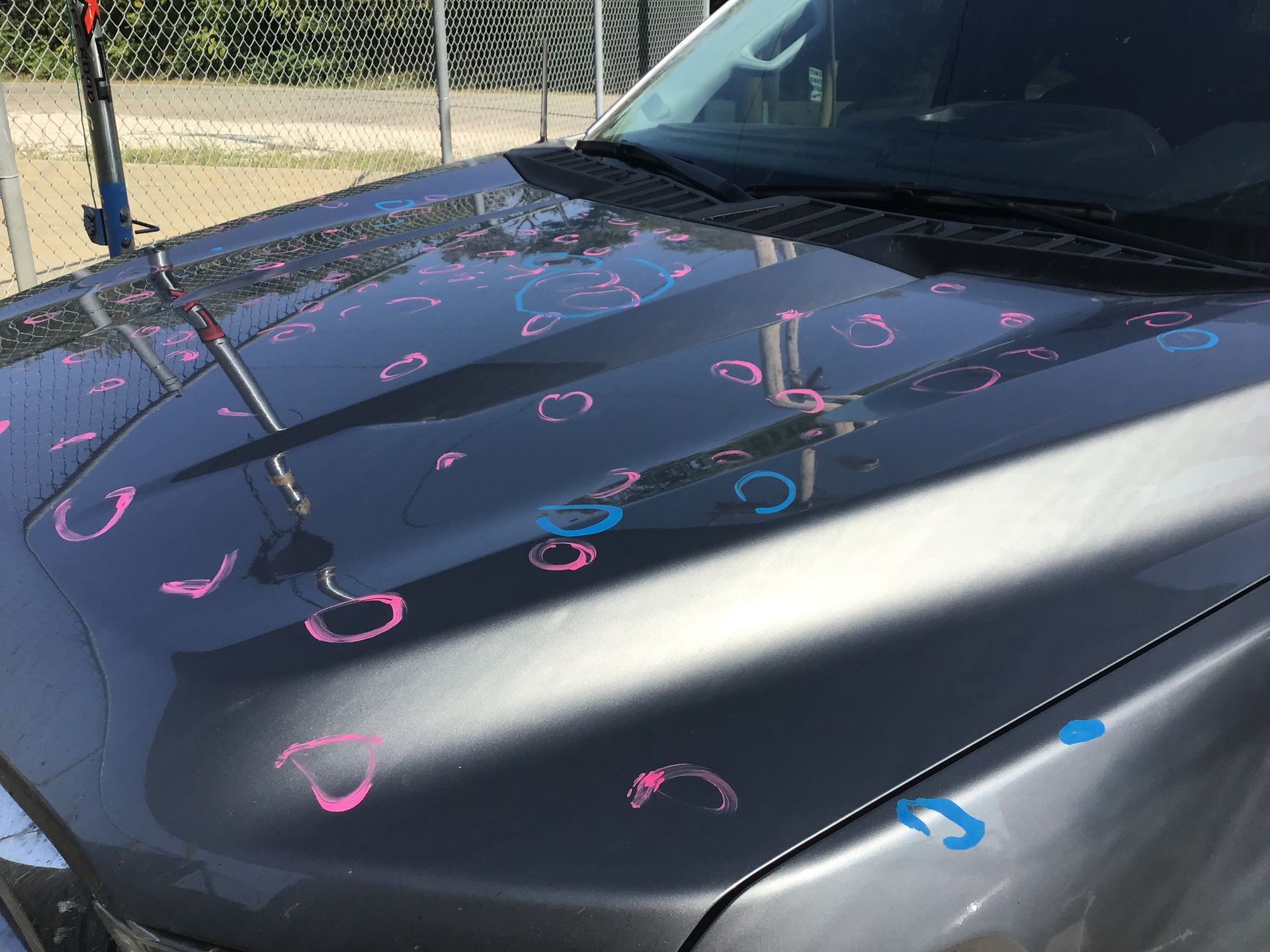 The hood of a car is covered in hail.