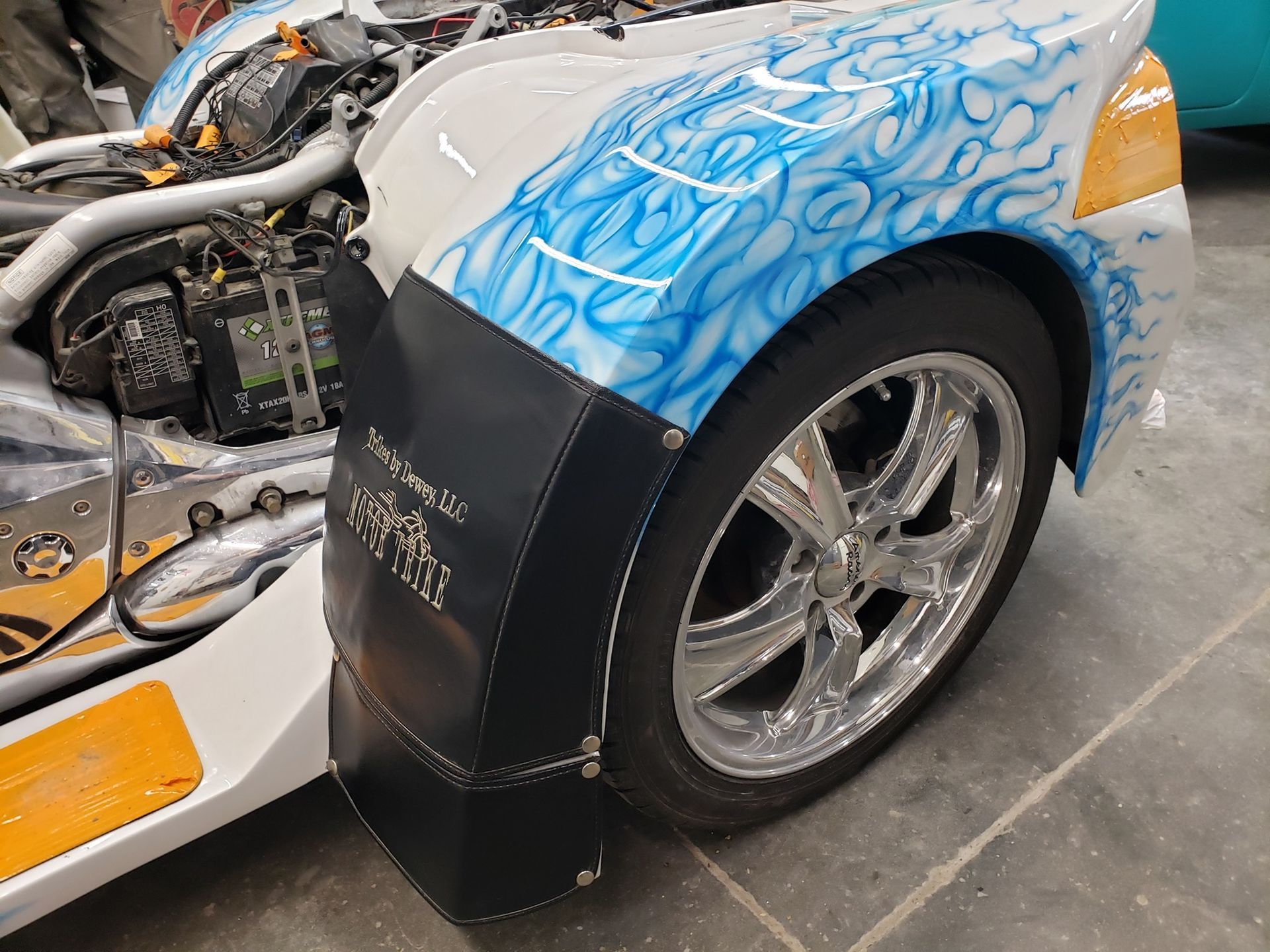 A close up of a motorcycle 's fender with flames painted on it