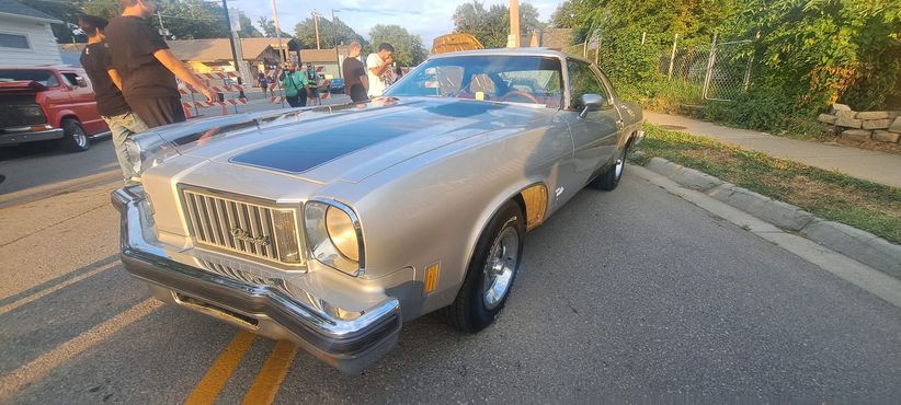 A silver car is parked on the side of the road.