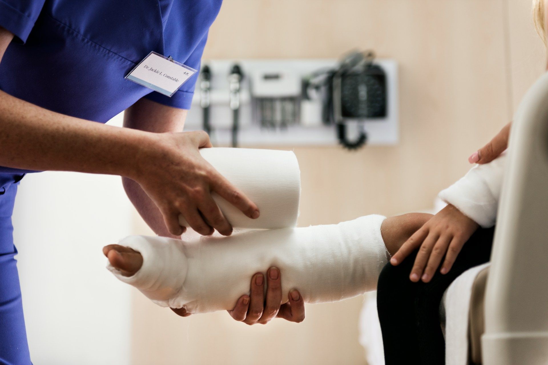 A nurse is wrapping a patient 's leg in a cast.