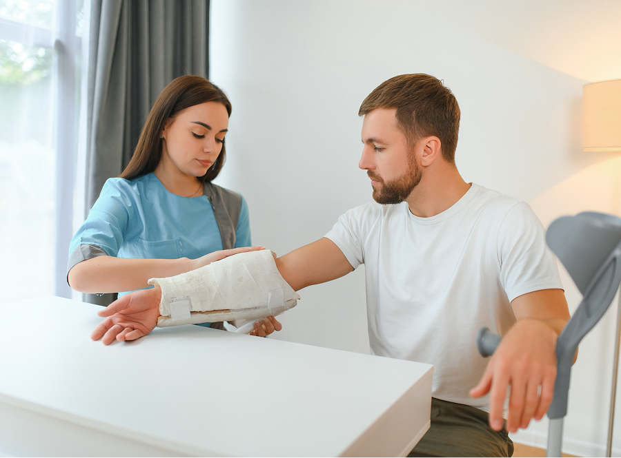 A woman is helping a man with a cast on his arm.