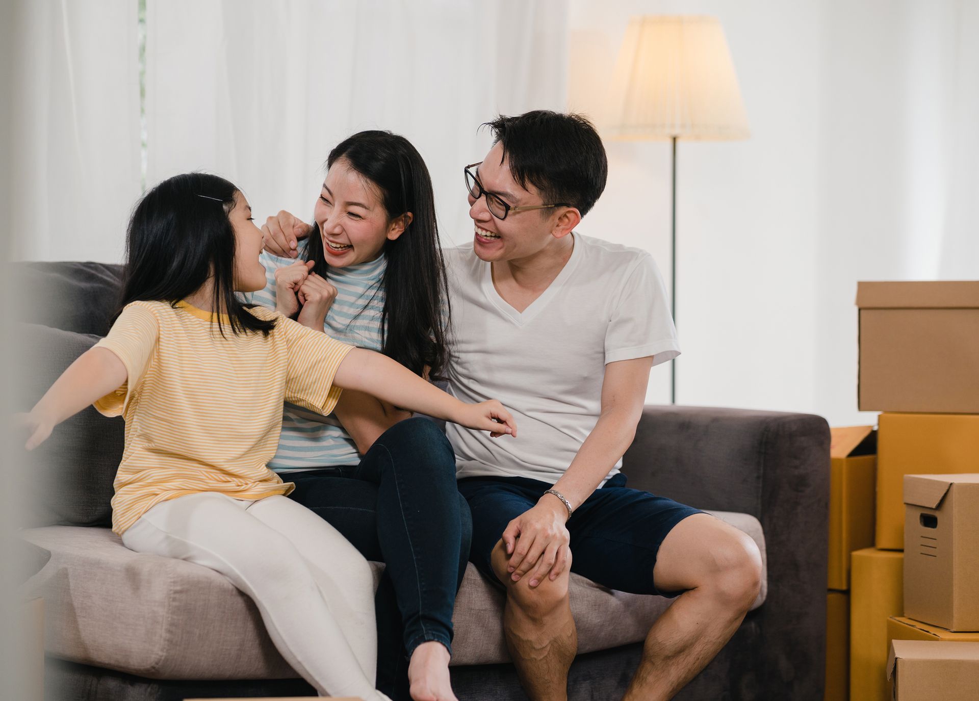 A family is sitting on a couch in a living room.