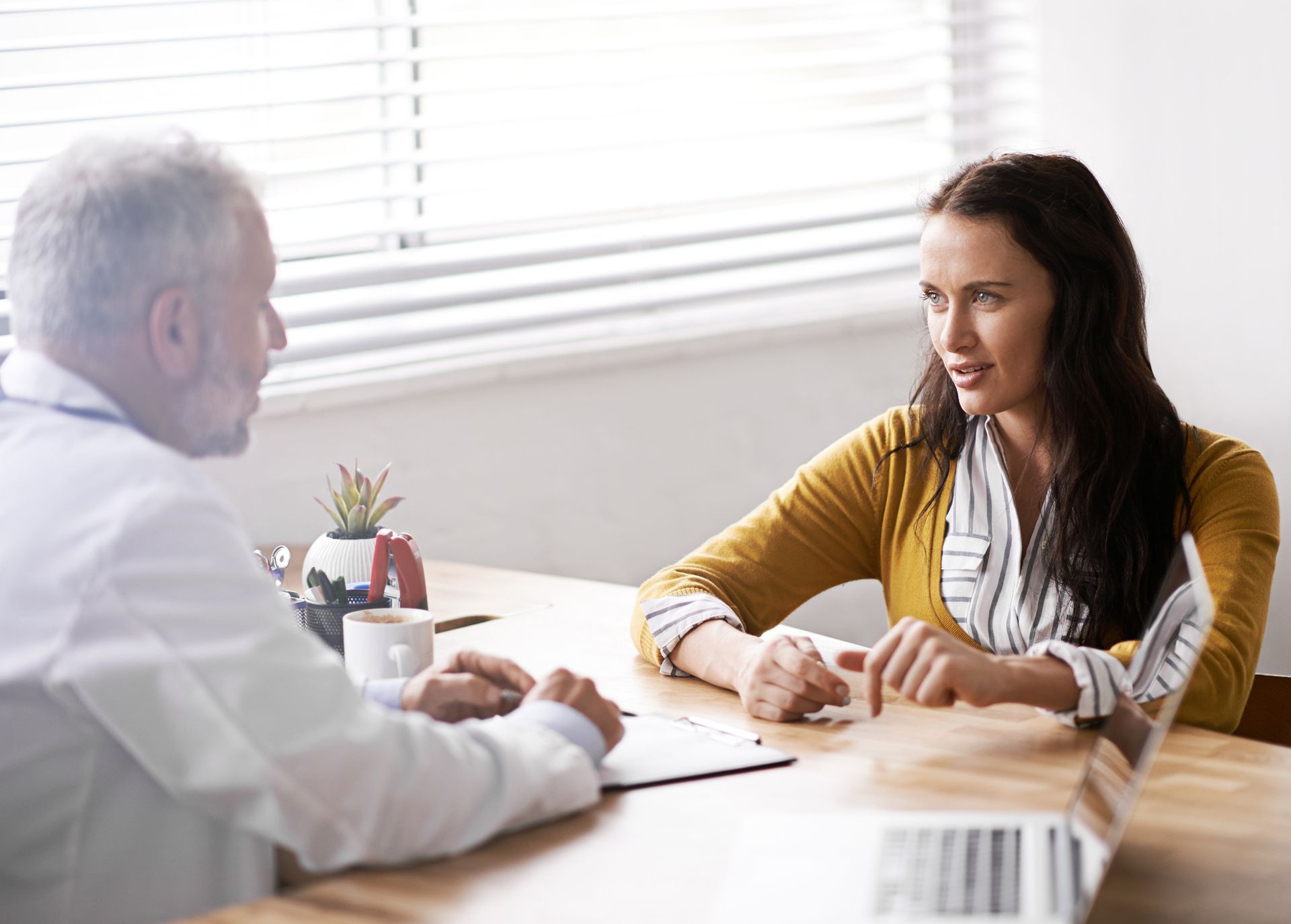 A man and a woman are sitting at a table having a conversation.
