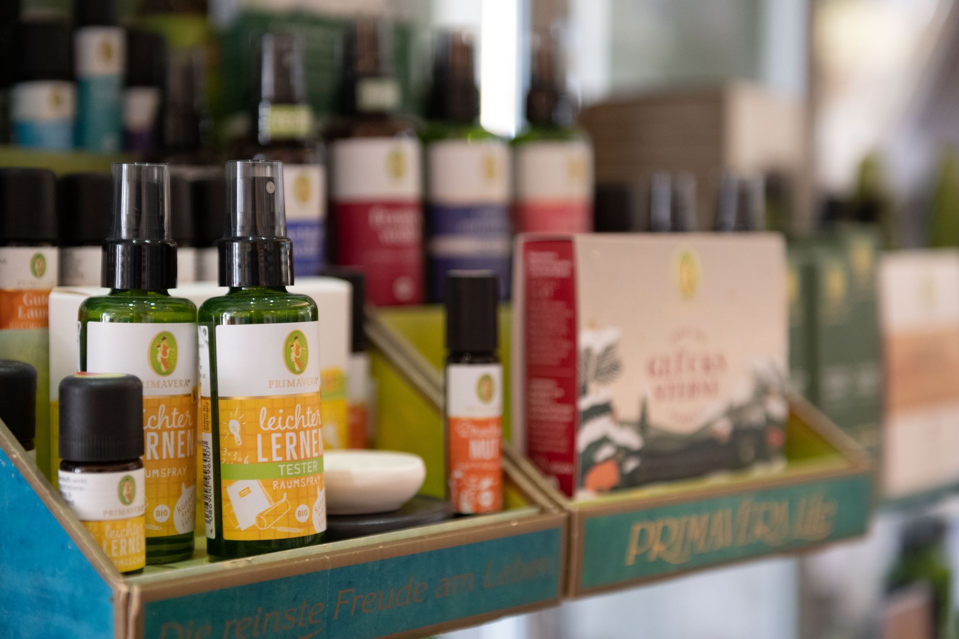Eine Ausstellung mit Flaschen ätherischer Öle auf einem Regal in einem Geschäft.