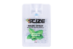 A bottle of suze mask spray is sitting on a rock.