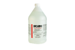 A bottle of scize sits on a rock near a river