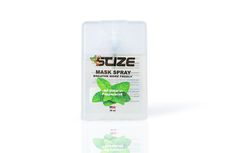 A bottle of suze mask spray is sitting on a rock.