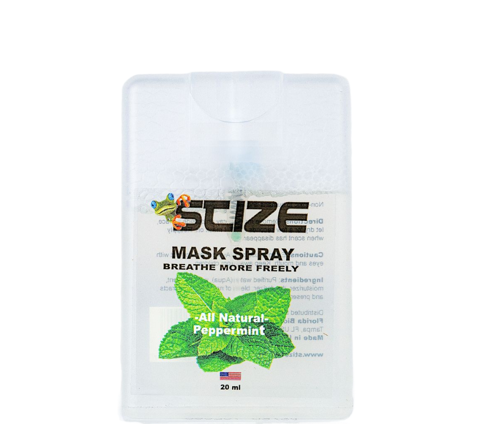 A bottle of suze mask spray is sitting on a rock.