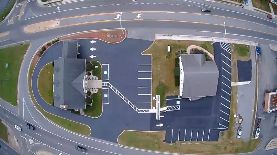 A construction worker is working on a parking lot.