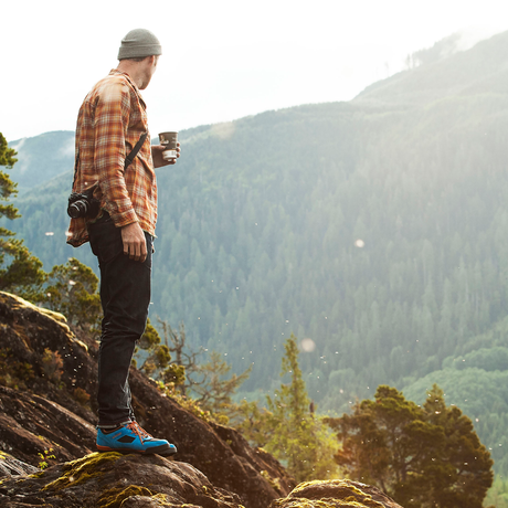 man hiking in ridgemont boots on a rugged cliff