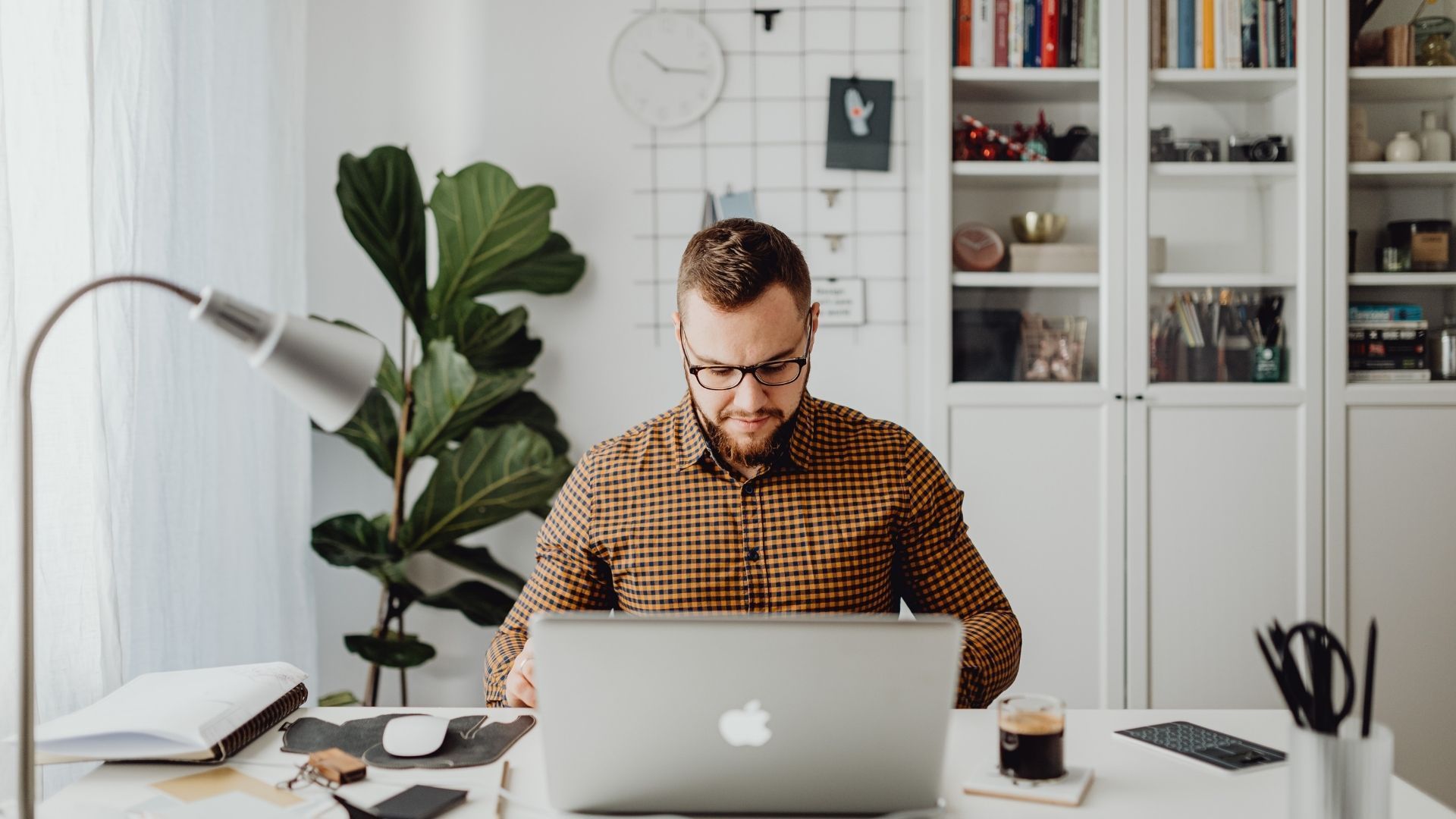 A man is sitting at a desk using a laptop computer.